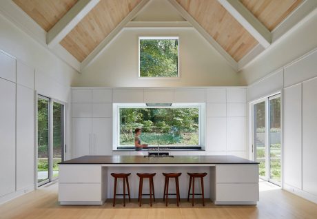 Spacious open-concept kitchen with vaulted ceiling, large windows, and modern island seating.
