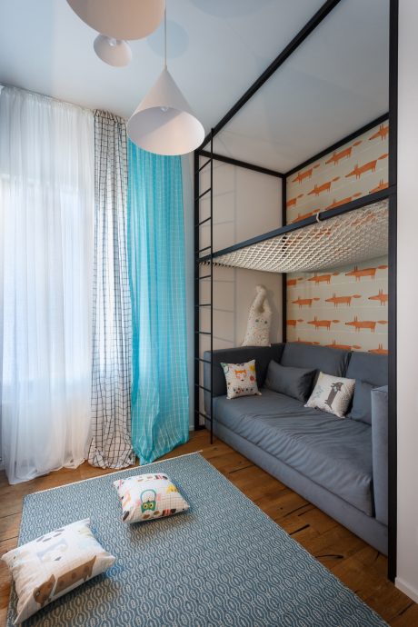 A modern, whimsical child's bedroom with a cozy loft bed, vibrant curtains, and patterned decor.