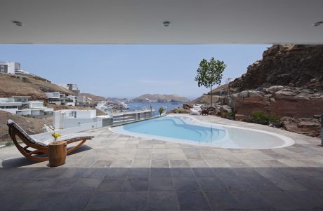 Stunning infinity pool overlooking the sea, with modern architecture and natural rock formations.
