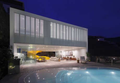 Striking modern architecture with illuminated pool and outdoor living area.