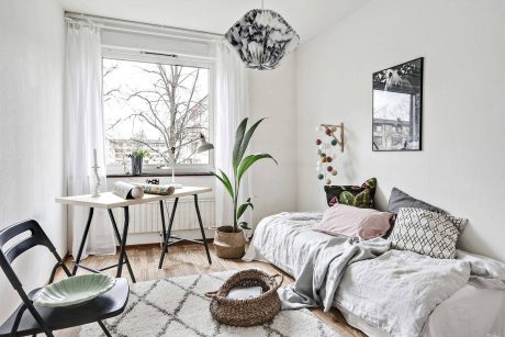 Cozy bedroom with modern furnishings, large window, and nature-inspired decor elements.