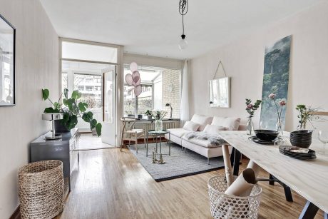 A bright, modern apartment interior with minimalist furniture and decorative elements.