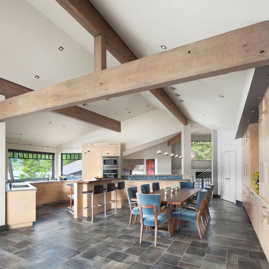 A spacious kitchen and dining area with wooden beams, tiled floors, and modern furnishings.