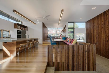 Bright, open-plan interior with wood paneling, kitchen island, and contemporary furniture.