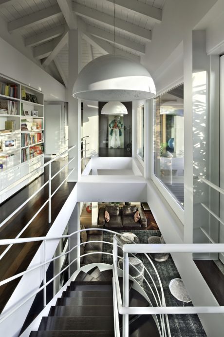 A bright, modern interior with a large, spherical pendant light and a cozy seating area.