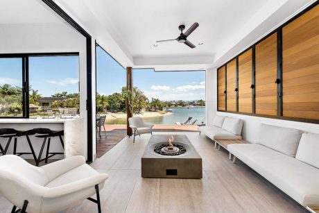 Sleek, modern living space with floor-to-ceiling windows, wood accents, and a firepit.