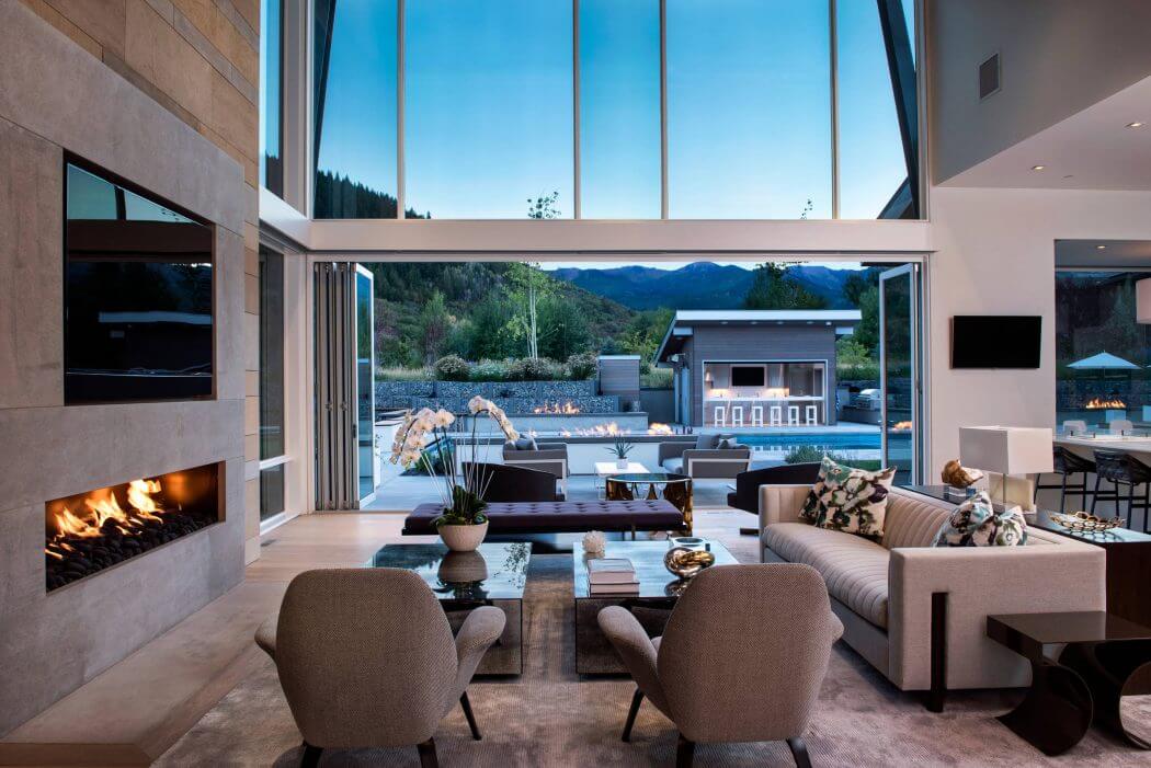 Stunning contemporary living room with panoramic mountain view, fireplace, and modern furniture.