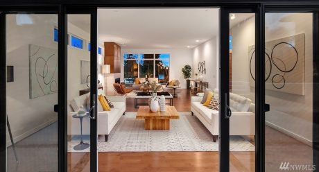 Elegant open-concept living area with modern furnishings, wooden accents, and abstract artwork.