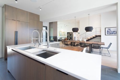 Spacious, modern kitchen with sleek wood cabinetry, double sinks, and open-concept dining area.
