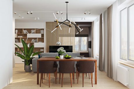 Open-concept living room with modern chandelier, wooden furniture, and built-in bookshelf.