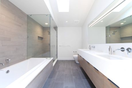 A modern and spacious bathroom with a large tub, glass shower enclosure, and vanity.