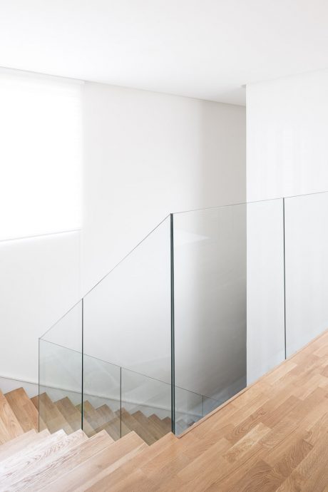 Sleek, modern staircase with glass panels and light wood steps. Elegant, minimalist design.