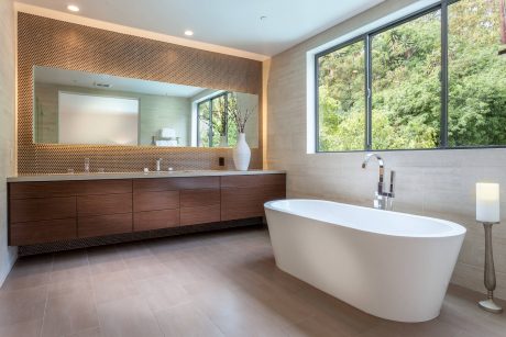 Spacious modern bathroom with wooden vanity, freestanding tub, and floor-to-ceiling windows.