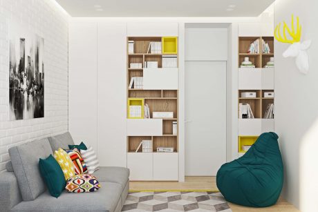 A modern, minimalist interior with built-in shelving, a gray sofa, and a green beanbag chair.