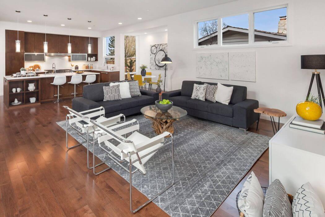 Bright, modern open-concept living space with hardwood floors, sleek kitchen, and cozy seating.