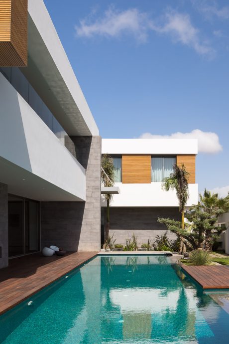Modern architectural design featuring sleek lines, concrete, and a serene pool.