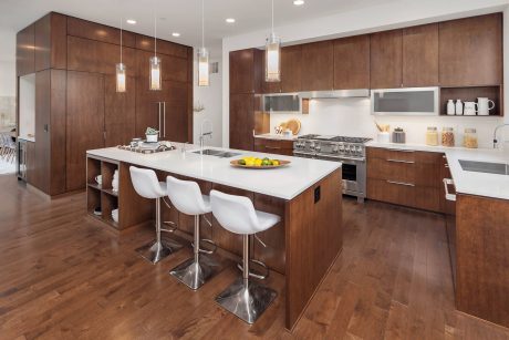 Well-appointed modern kitchen with sleek wooden cabinetry, island counter, and pendant lighting.