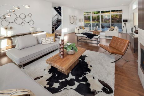 Minimalist living room with wooden furniture, metal accents, and a cowhide rug.