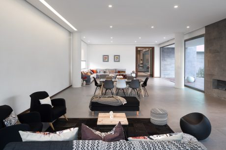 Minimalist living space with modern furnishings, lighting, and concrete flooring.