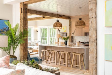 Rustic open-concept kitchen with wood beams, pendant lighting, and natural furnishings.