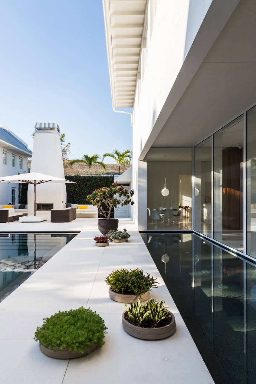 Sleek modern architecture with lush greenery surrounding a reflective pool.