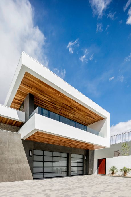 Striking architectural design featuring contrasting materials - wood, concrete, glass.