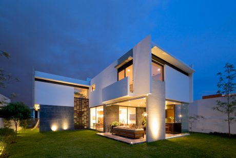 Striking modern architecture with a glass-walled interior and outdoor living area.