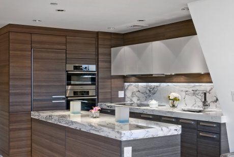 Stylish modern kitchen with sleek wood cabinetry, marble countertops, and stainless steel appliances.