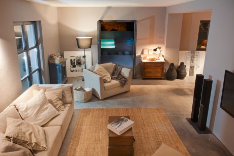 Cozy living room with warm tones, plush sofa, wooden furniture, and eclectic decor.