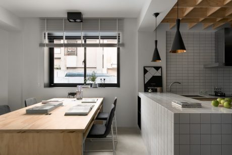 Sleek and modern kitchen with wood tones, metal accents, and geometric tiled backsplash.