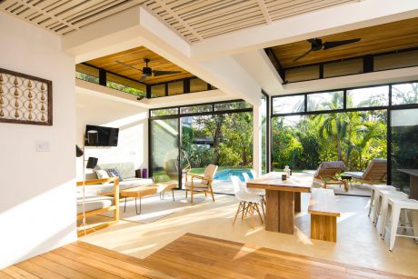Inviting open-concept living space with wooden accents, modern furnishings, and lush outdoor views.