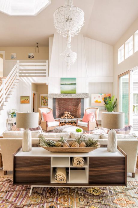 Bright, open-concept living space with high ceilings, rustic fireplace, and modern furnishings.
