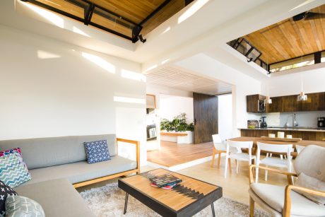 An open-concept living room with a vaulted wooden ceiling and a sleek, modern design.