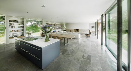 A modern, open-plan living space with a sleek kitchen and extensive bookshelves.