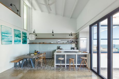 A modern, open-concept kitchen with a neutral palette, sleek fixtures, and a cozy dining nook.