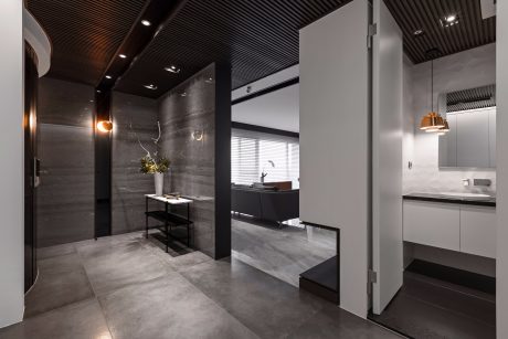 Sleek, modern interior with dark wood accents, gray tiled floors, and recessed lighting.