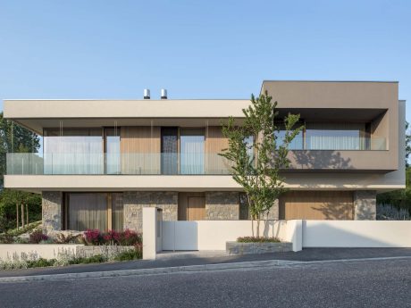 Sleek, contemporary façade with natural materials, varied textures, and balconies.