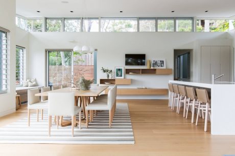 Expansive open-plan living area with abundant natural light, modern furniture, and wood accents.