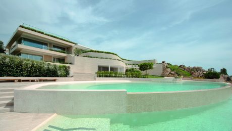 Sleek modern architecture with lush greenery and an inviting pool.
