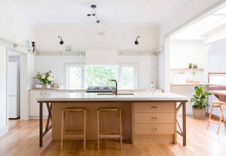 Bright, airy kitchen with white subway tiles, wood cabinetry, and a marble-topped island.