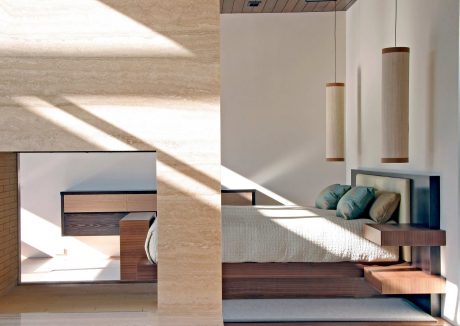 Modern bedroom showcases minimalist design with wooden furnishings, recessed lighting, and geometric shapes.