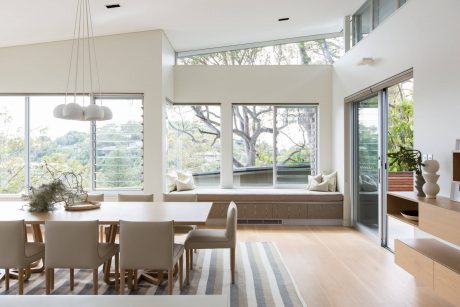 Spacious open-concept living area with large windows offering scenic forest views.