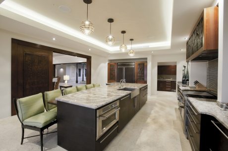 Spacious kitchen with sleek granite countertops, wood cabinetry, and modern pendant lighting.