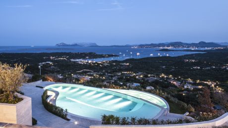 Stunning infinity pool overlooking a picturesque coastal landscape at dusk.