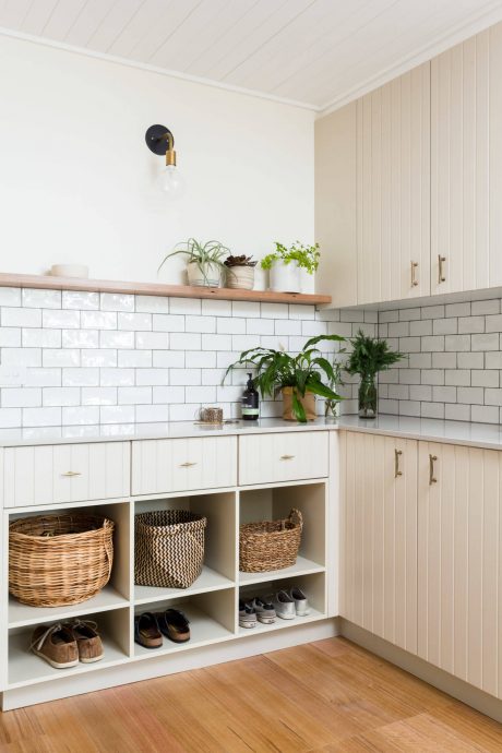 Cozy kitchen with wooden shelves, subway tile backsplash, and built-in storage cubbies.