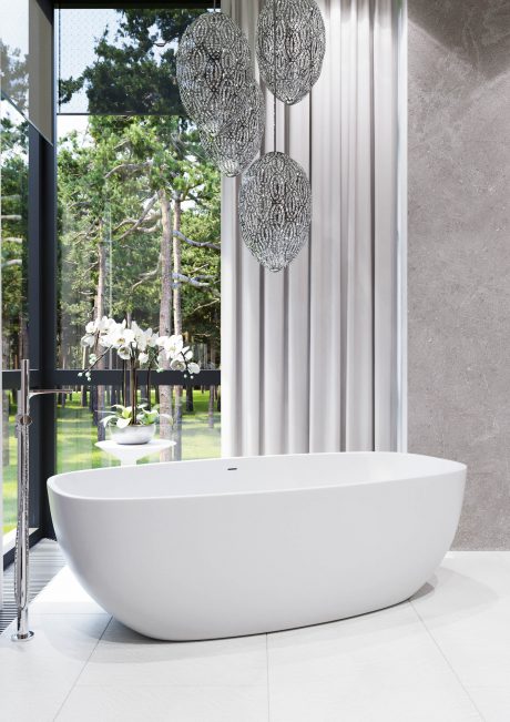 Sleek, modern bathroom with a freestanding white tub, ornate light fixtures, and a lush outdoor view.