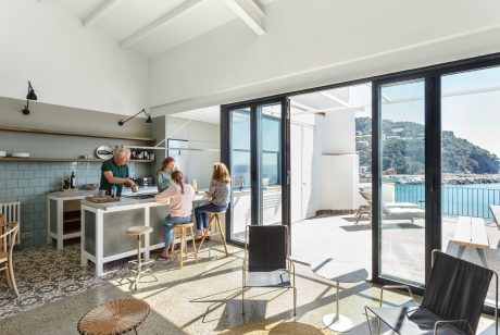 A bright, modern kitchen with large windows overlooking a scenic coastal landscape.