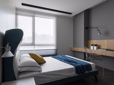 Well-designed contemporary bedroom with large windows, minimalist furnishings, and warm wood accents.