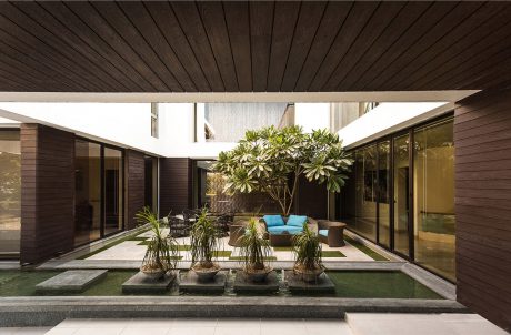 An inviting modern indoor-outdoor living space with lush plantings and minimalist decor.