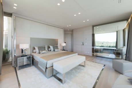 Spacious, modern bedroom with sleek, minimalist furniture and lighting design.